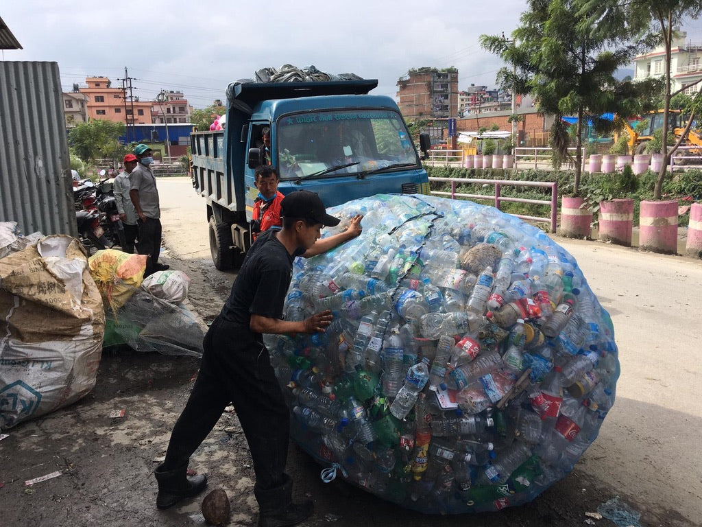 Person mit vielen Plastikflaschen recycling gegen die Plastikkrise WasteReduction 